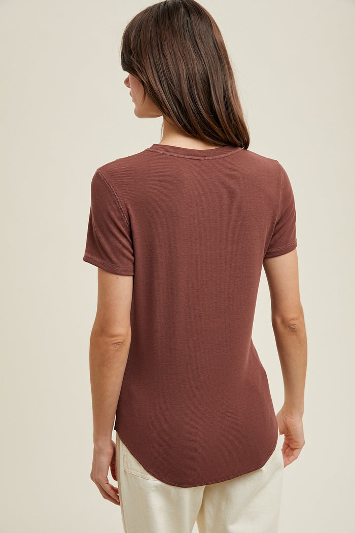 woman wearing a brown short sleeve top with a ribbed texture and a rounded hem, seen from the back