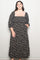 woman wearing a black floral maxi dress with puff sleeves and a square neckline, smiling at the camera