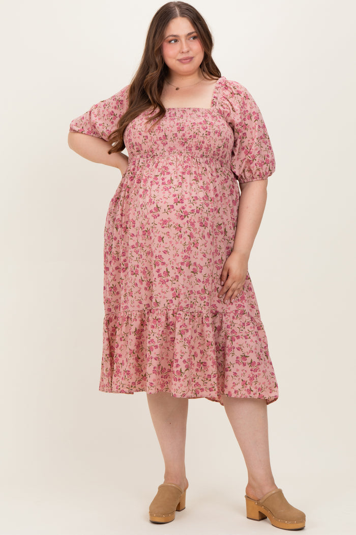 woman wearing a pink floral maternity dress with puff sleeves and ruffle hem, showing her baby bump