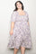woman wearing a purple floral plus size dress with a square neckline and puff sleeves