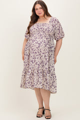 woman wearing a floral print maternity plus dress with a square neckline and puff sleeves, showing a visible baby bump