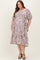 woman wearing a floral print maternity plus dress with a square neckline and puff sleeves, showing a visible baby bump