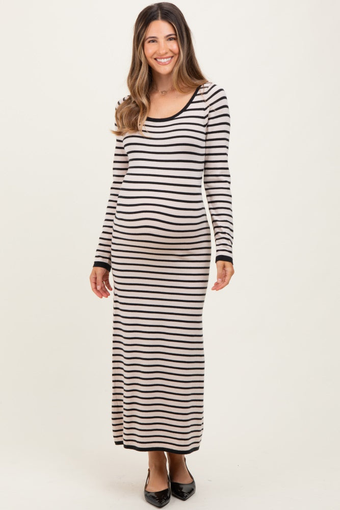 woman wearing a black and cream striped maternity maxi dress and showing her baby bump