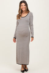 woman wearing a black and cream striped maternity maxi dress and showing her baby bump