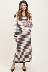 woman wearing a black and cream striped maternity maxi dress and holding her baby bump