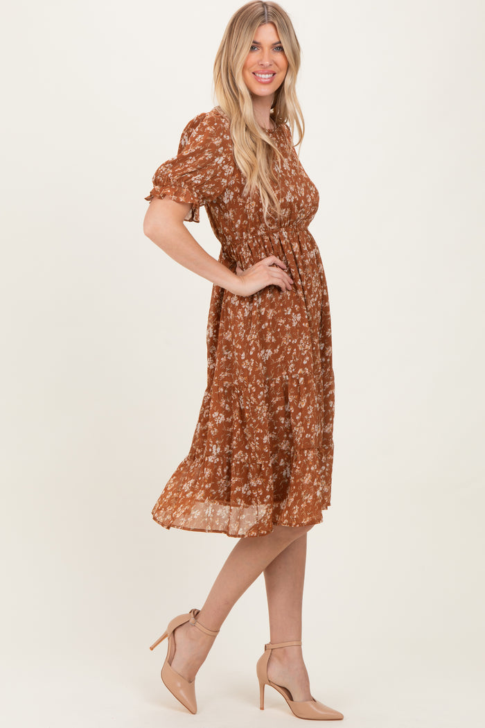 woman wearing a rust floral midi dress with puff sleeves and a cinched waist, paired with nude high heels