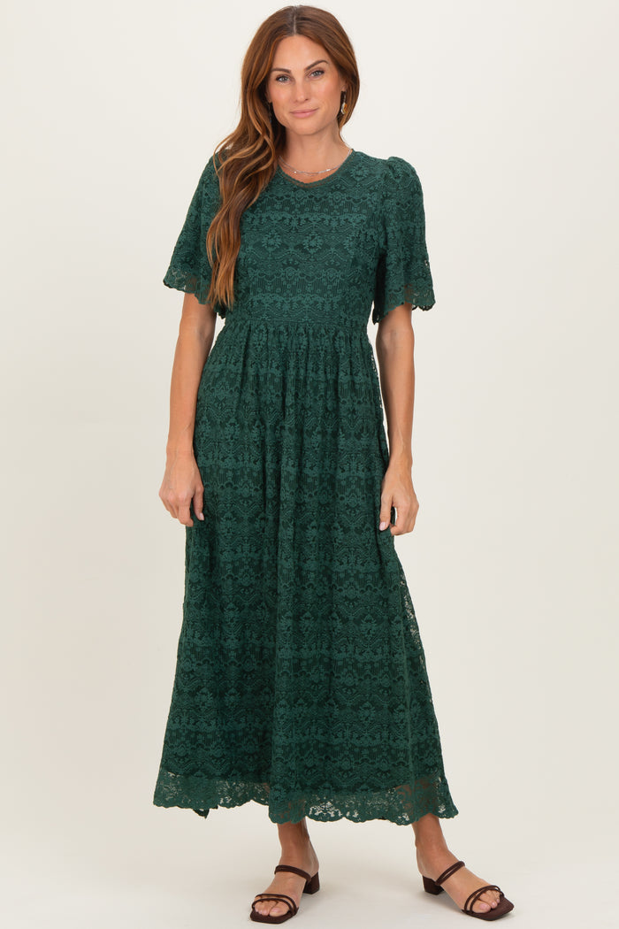 woman wearing a dark green lace maxi dress with short sleeves and a flared skirt