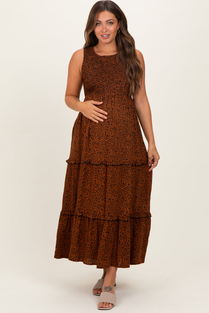 woman wearing an orange leopard print maternity maxi dress and holding her baby bump
