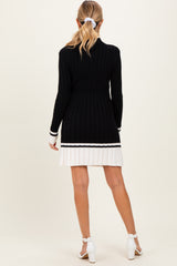 woman wearing a black and white striped maternity sweater dress with ribbed texture, displaying a baby bump