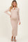 woman wearing a beige long sleeve maternity dress with a bow tie detail and a visible baby bump