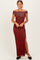 woman wearing a burgundy off-shoulder maxi dress with floral print and a side slit