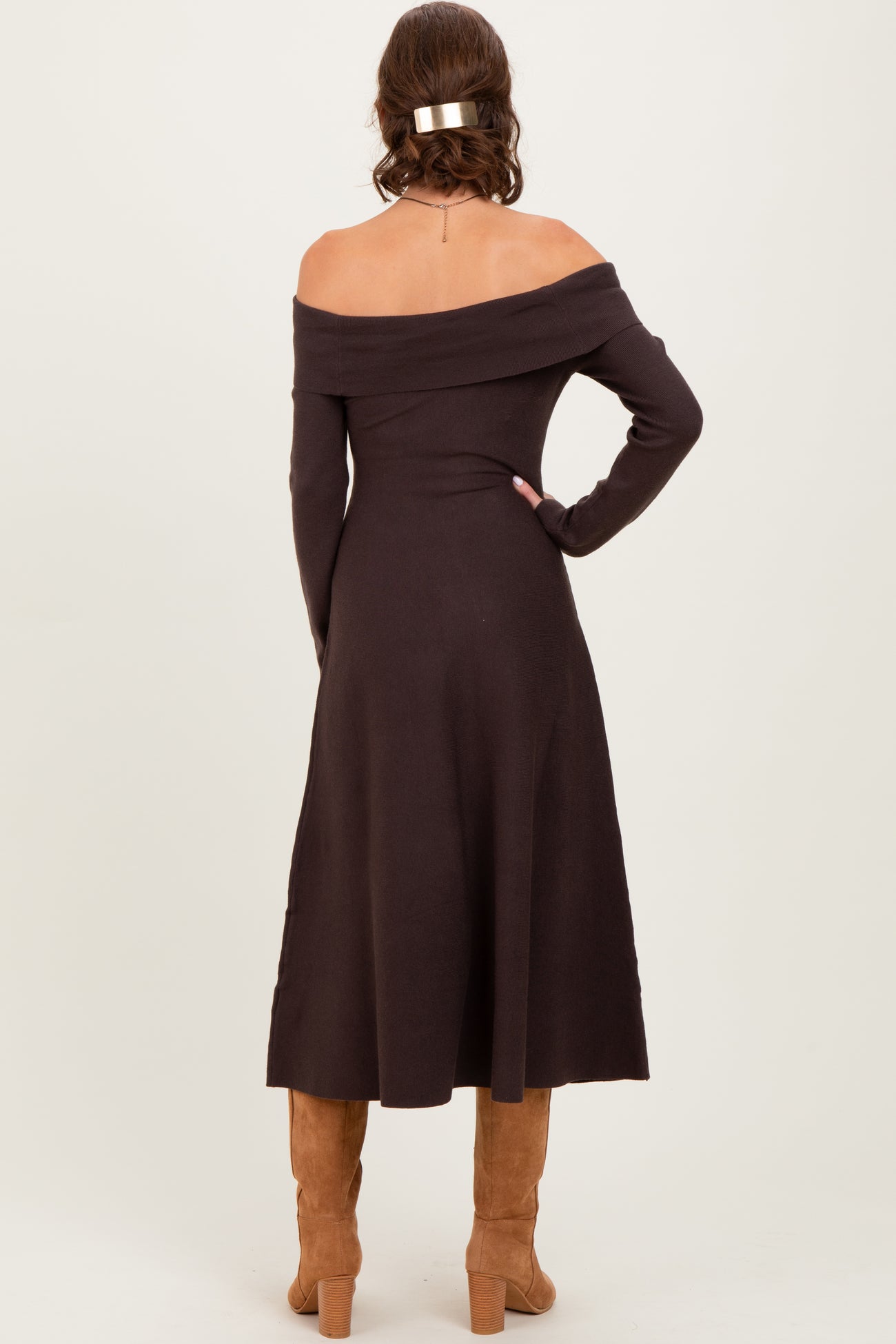 woman wearing a chocolate brown off-the-shoulder midi dress with long sleeves and a fitted silhouette