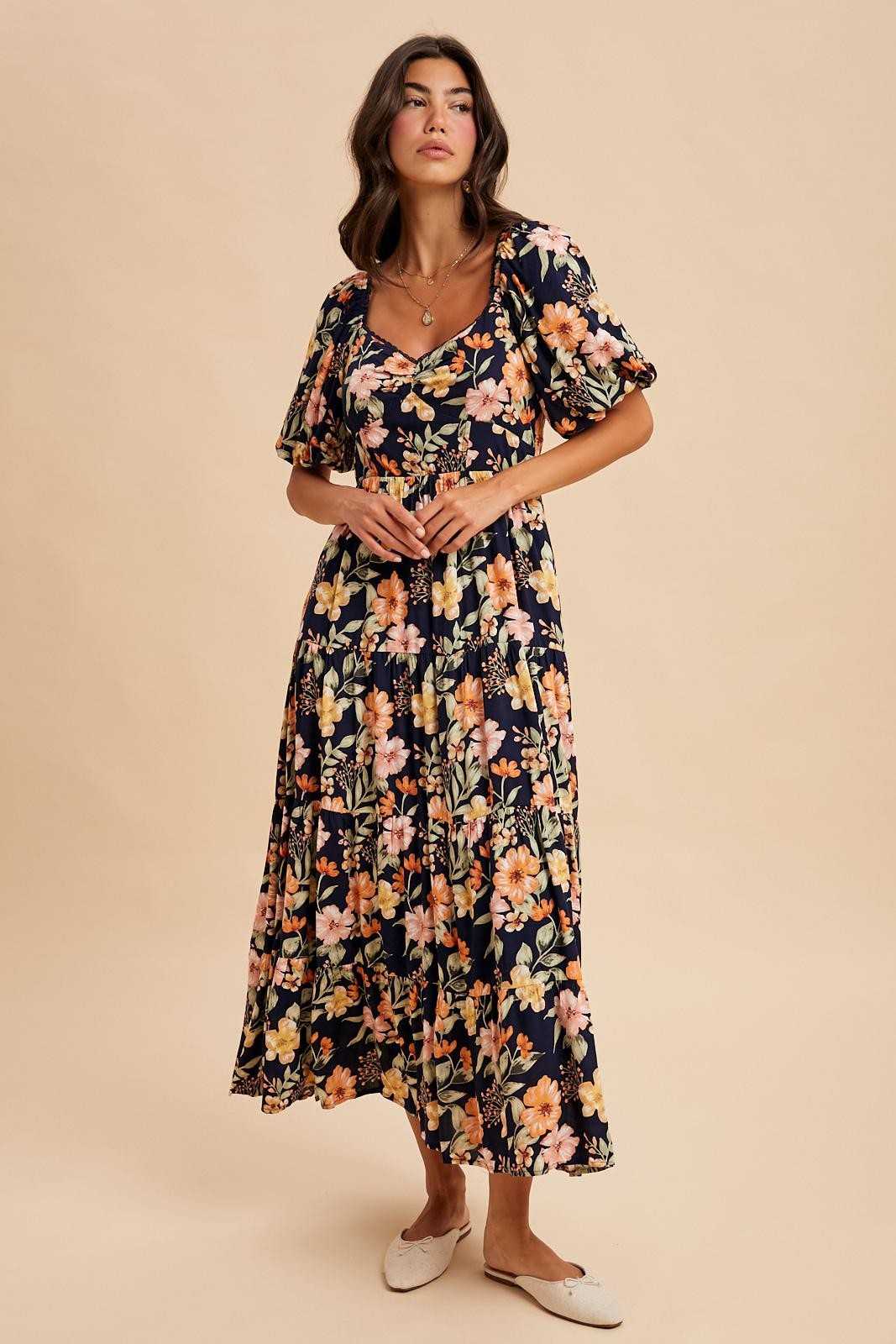 woman wearing a floral maxi dress with short puff sleeves and a square neckline