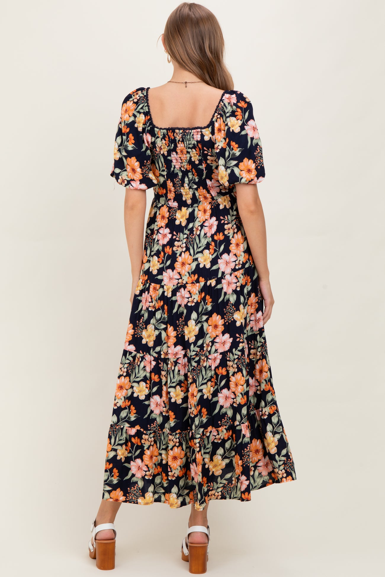 woman wearing a floral print maternity maxi dress with short puff sleeves and a square neckline, showing her baby bump