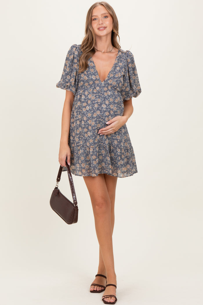 woman wearing a floral print short sleeve maternity dress and holding her baby bump