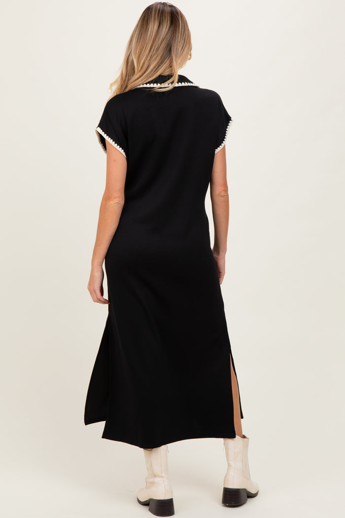 woman wearing a black maternity dress with short sleeves and side slits, showcasing a relaxed fit