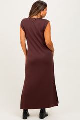 woman wearing a long brown maternity dress with cap sleeves and a side slit, showcasing a smooth silhouette