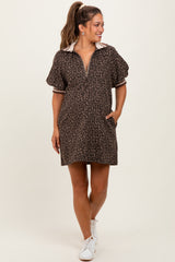 woman wearing a leopard print maternity dress with a polo collar and short sleeves, featuring pockets and styled with white sneakers