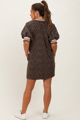 woman wearing a leopard print maternity dress with short sleeves and a polo collar, showing her back