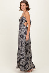 woman wearing a black and white patterned maxi dress with cut-out details and a tie at the back