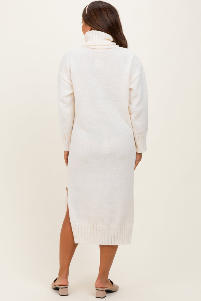 woman wearing a cream-colored maternity sweater dress with a turtleneck and side slits
