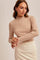 woman wearing a beige ribbed long sleeve top with a mock neck and paired with a cream pencil skirt