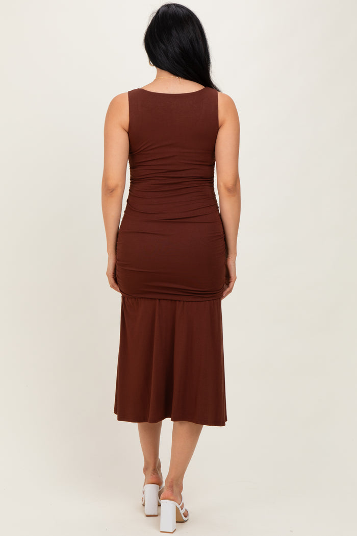 woman wearing a brown sleeveless midi dress with ruching details at the back and a fitted silhouette