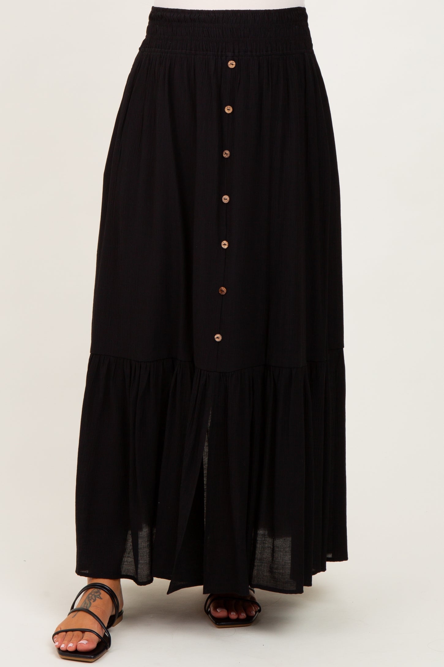 maternity wear black tiered maxi skirt with button detailing and an elastic waistband, styled with sandals