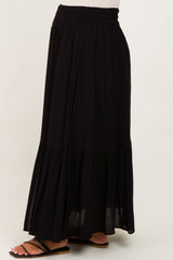 woman wearing a black maternity maxi skirt with a tiered design and elastic waistband