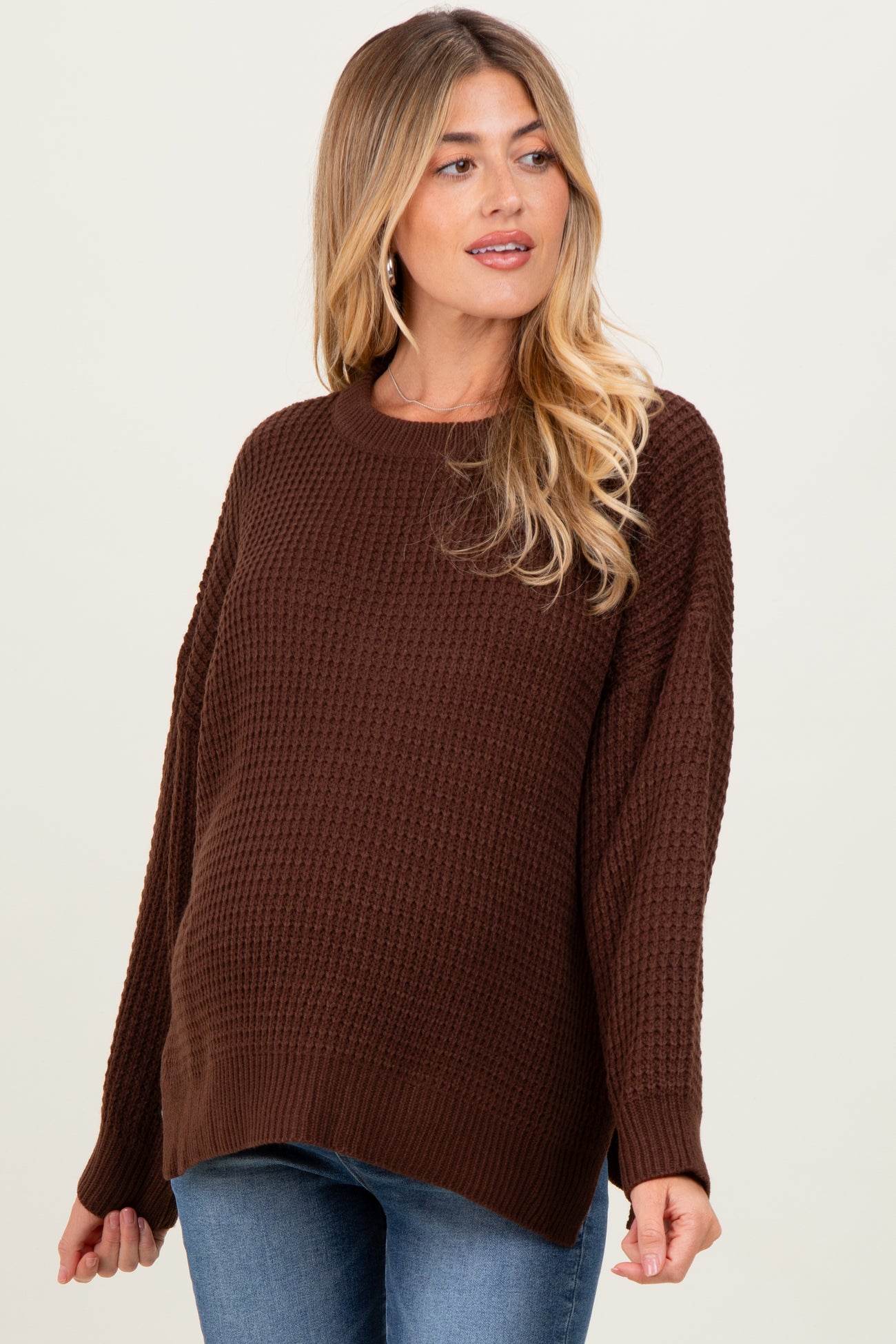woman wearing a brown textured maternity sweater with a relaxed fit and visible baby bump