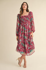 woman wearing a burgundy floral maxi dress with puff sleeves and smocked bodice