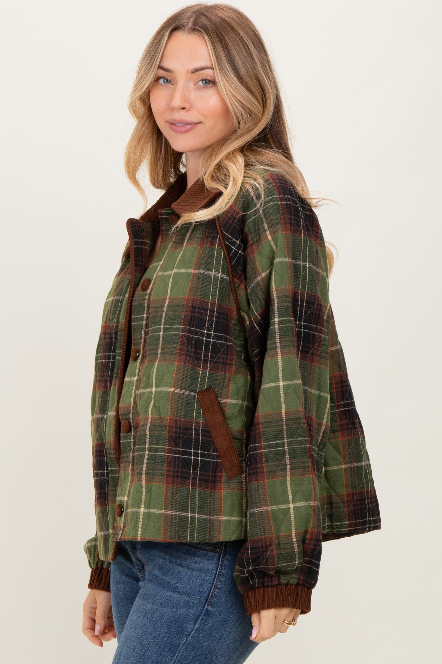 woman wearing a green and brown plaid jacket with a button front and ribbed cuffs