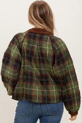 woman wearing a green and brown plaid oversized jacket with a brown collar and back view visible