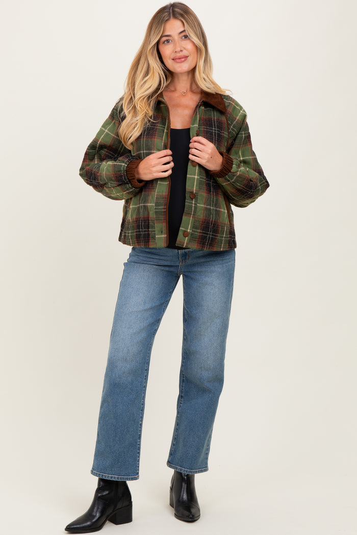 woman wearing a green plaid maternity jacket with a black top and blue jeans