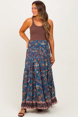 woman wearing a brown tank top and a floral print navy blue maternity maxi skirt with a tiered design