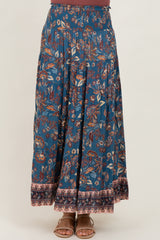 woman wearing a long flowy blue bohemian maxi skirt with floral patterns and a wide waistband