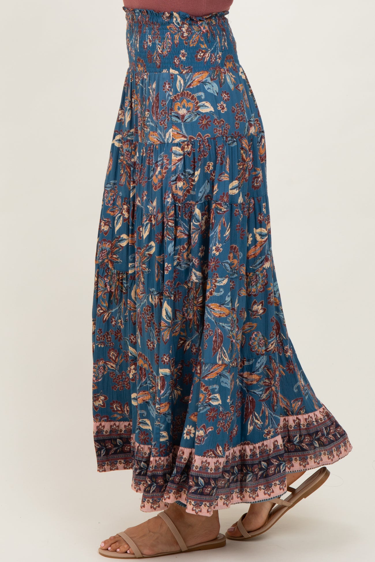 woman wearing a blue floral maxi skirt with elastic waistband and ruffle hem