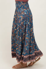 woman wearing a blue floral maxi skirt with elastic waistband and ruffle hem