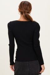 woman wearing a black ribbed long sleeve top with puff shoulders, shown from the back