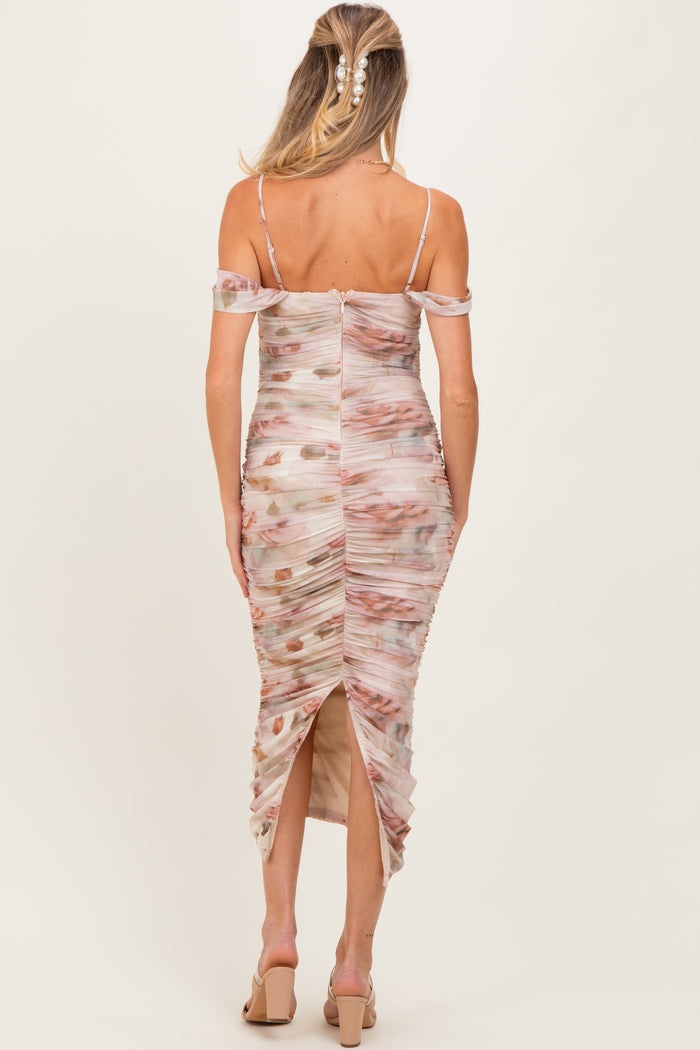 woman wearing a lightweight pink floral maternity dress with ruched detailing and off-shoulder straps, showing a baby bump