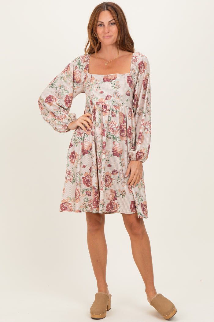 woman wearing a floral print square neck dress with long puff sleeves and a relaxed fit