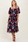 woman wearing a black floral midi dress with puff sleeves and a square neckline