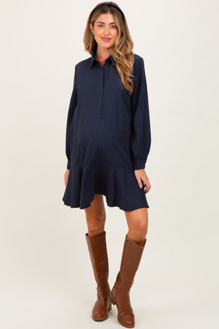 woman wearing a navy striped maternity shirt dress with a flared hem and brown knee-high boots, showing her baby bump