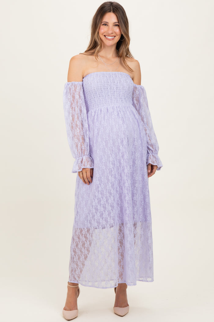 woman wearing a lavender off-the-shoulder maternity dress with long sleeves and a flowy skirt, showing her baby bump