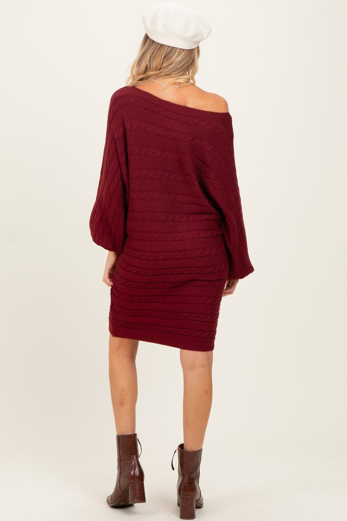 woman wearing a burgundy off-the-shoulder cable knit maternity sweater dress, view from the back