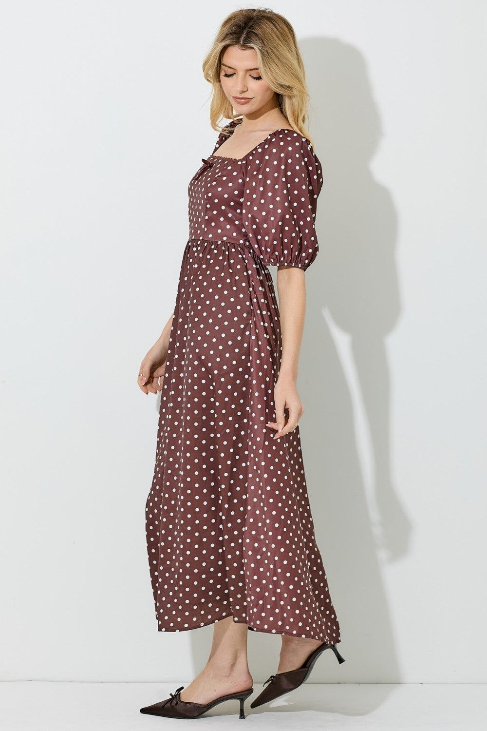 woman wearing a brown polka dot maxi dress with puffy sleeves and a square neckline