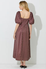 woman wearing a brown polka dot midi dress with puff sleeves and a smocked back view