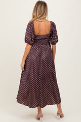 woman wearing a brown polka dot maternity dress with a smocked bodice and puff sleeves, showing a baby bump from behind