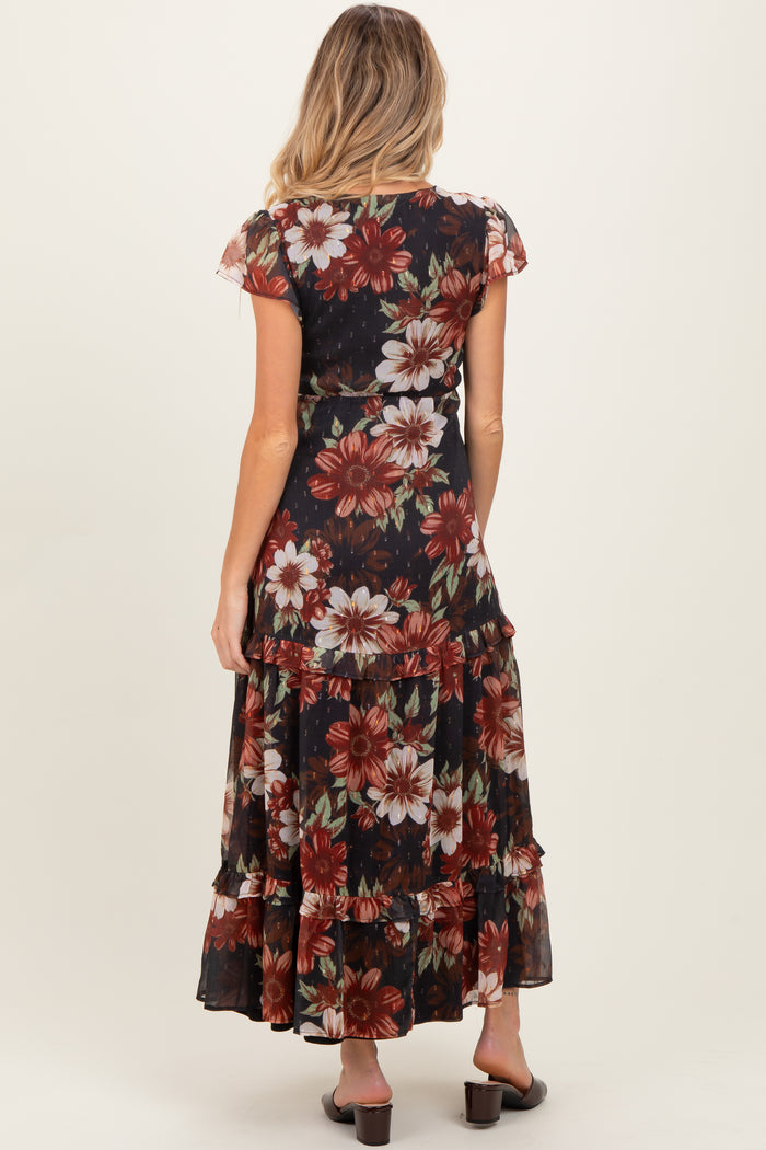 woman wearing a black floral maternity maxi dress with cap sleeves and a tiered skirt