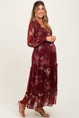 woman wearing a burgundy floral tiered maternity dress and showing her baby bump